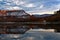 Woman with a lamp standing on the river bank with a view of Fisher Towers and La Sal Mountains under snow.