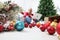 Woman with laptop computer prepare christmas tree with cardboard boxes full of christmas balls and decorations, preparation