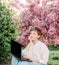 Woman with laptop connection smile relax outside sakura