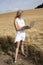 Woman with laptop in field of barley