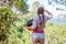 A woman with a laptop at the top of the mountain looks into the distance. The tourist industry worker plans the route and