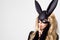 woman with large breasts wearing a black mask Easter bunny standing on a white background