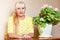 Woman and large flowering pelargonium indoors