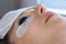 Woman on lash lifting laminating painting procedure in beauty clinic, closeup.