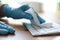 Woman in latex gloves cleaning computer keyboard with wet wipe at table