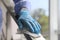 Woman in latex gloves cleaning railing with wet wipe, closeup