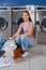 Woman With Laundry Basket Sitting In Front Of