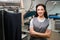 Woman laundry office worker smiling standing near automatic ironing mannequin