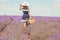 Woman on the lavender field. Woman in blue dress and  white hat  back view. Goes on lavender rows. girl in blue dress and white