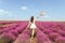 Woman on the lavender field. Woman in white dress and   hat  back view. Goes on lavender rows. girl in white dress and white hat