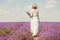 Woman on the lavender field. Woman in white dress and   hat  back view. Goes on lavender rows. girl in white dress and white hat