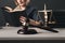 Woman lawyer reading professional books in office. Wooden gavel and libra on the desk.