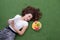 Woman lay down or relaxing on green grass reading book in summer or spring, top view