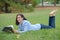 Woman layed on grass reading magazine