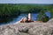 Woman laying on cliff an relaxing above the lake Yastrebinoye, Priozersky district in Leningrad region, Russia