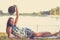 Woman laying in a meadow in front of a lake