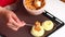 A woman is laying minced meat with carrots in rosettes of mashed potatoes on a baking sheet.