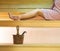 Woman laying on sauna bench wearing pink towel. Long legs resting and relaxing.