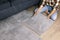 woman laying self adhesive carpet tiles on floor in living room