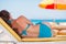Woman laying on sunbed on beach