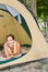 Woman laying in tent using cell phone