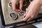 A woman lays curls filled with poppy and walnuts on a baking sheet. Nearby on the table are ingredients and tools