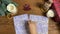 Woman lays out blue paper with patterns and scissors on wooden table.