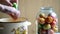 Woman lays tomatoes and cucumbers in jars. Home