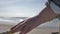 Woman leads hand on rope near the sea close up