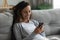 Woman leaned on sofa enjoy lazy weekend with smartphone