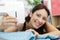 Woman leaning around sewing machine to smile at camera