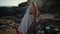 Woman is leaning on basalt rocks near sea in summer