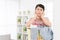 Woman leaning on laundry basket feeling bored