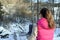 Woman leaning to snowy fence