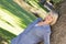 Woman leaning on tree trunk in parkland