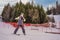 Woman learning to ski. Young woman skiing on a snowy road in the mountains