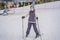 Woman learning to ski. Young woman skiing on a snowy road in the mountains