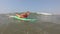 A woman learns to swim on a surfboard and catches a wave. Man learns to surf