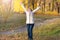 Woman with leaves in the autumn Park on a background of yellow blurred leaves