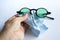 Woman left hand cleaning black sunglasses by microfibre cleaning cloths, On white background, Close up shot, Optical concept