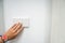Woman left hand with cute watch turn off the office light switch for energy savings