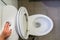 Woman left hand flush the toilet for hygiene