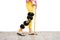 Woman leg in an orthosis standing on the floor isolated.