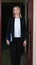 woman legal adviser or lawer wearing formal clothes standing next to door and holding documents. young judge assistant