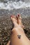 Woman legs on beach and stone feet