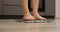 Woman legs checking weight. Female barefoot on scales measuring weight, close up. Weight loss concept