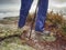 Woman legs in high waterproof boots make step over water