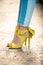 Woman legs in leather yellow high heel sandals outdoor in city