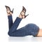 Woman legs lying with jeans and sandal heels pointing up