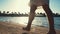 Woman legs making steps at sunny beach. Unrecognizable girl walking at seaside.